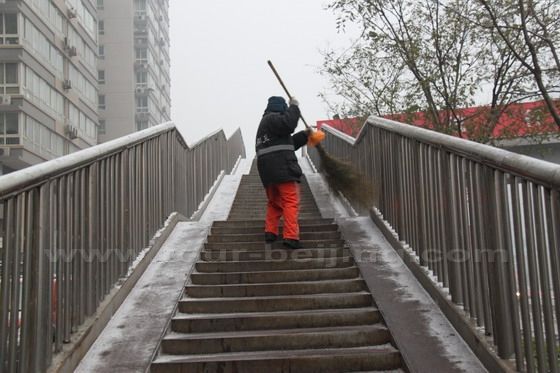 A snow clearing worker is clearing the snow from the flyover.