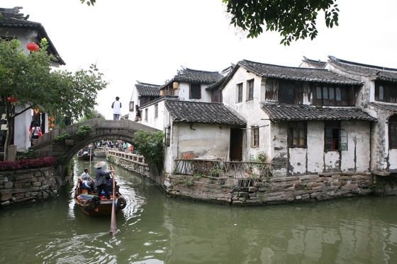 A stone hump bridge spans an narrow river