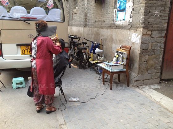 A street hairdresser is having a haircut for low-income dweller