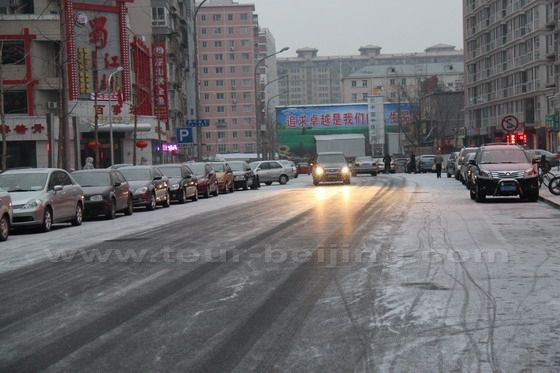 Cars are moving slowly on the newly fallen snow on the road
