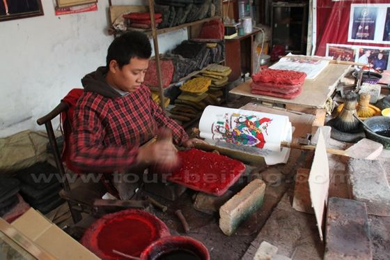 He is brushing the red color on  the block