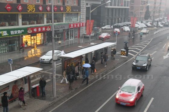 Many commuters are waiting  for their buses at the bus station below the flyover.