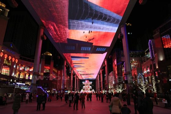 People just stand in awe gaping up a 100 feet above at the football size screen
