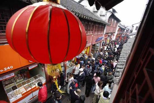 The narrow lane is packed with people.