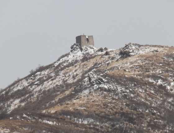 Standing on the round stone mound, you can see the highest wacth tower of the Great Wall around Beijing with the sea-level of 1400 meters