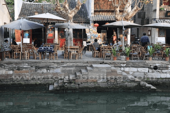 Take a break at a canal side food stall for a bite of local food.