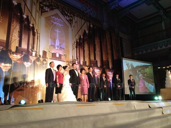 The bride and the groom and their parents are up on the platform