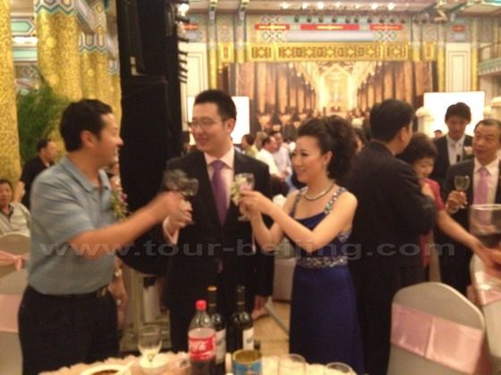 The bride and the groom is coming to each table to make a toast.