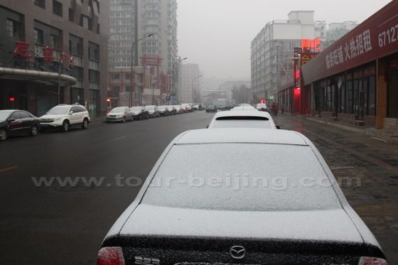 The cars parking on the roasides hold the snow