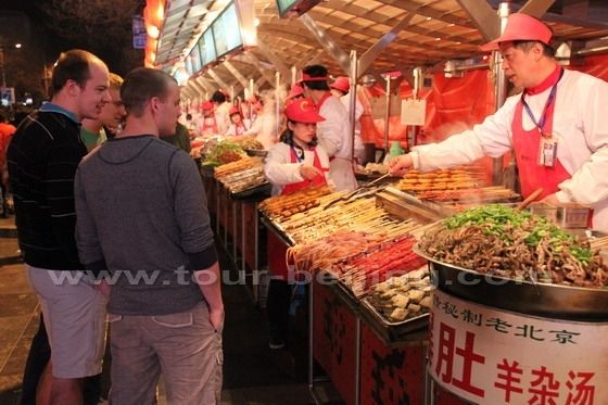 The foreign tourists are curious about the snake meat.