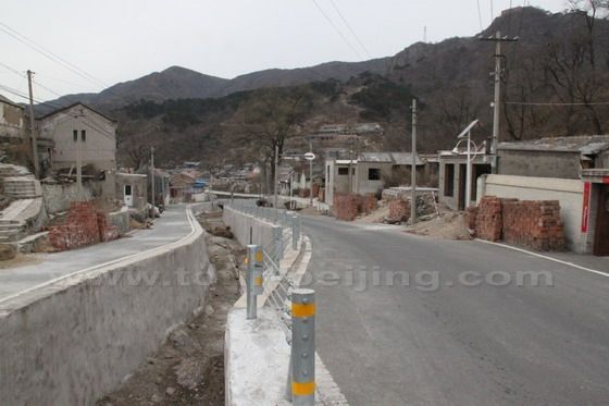 The gully and the main road go shoulder to shoulder sandwiched by the village houses on the two sides.