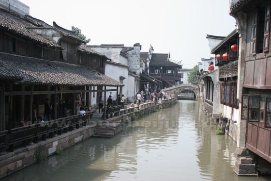 The narrow street with long chairs goes along the canal