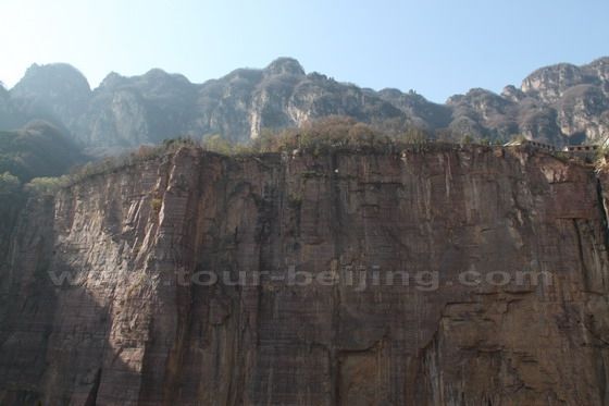 The precipice opposite the cliff with the carved road is upright as if knifed and axed with houses on the top. 