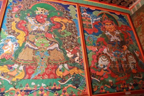 The tangka paitings on the wall by the entrance to the temple.