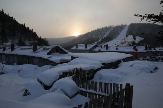The traditional houses are blanketed in the sunrise glow.