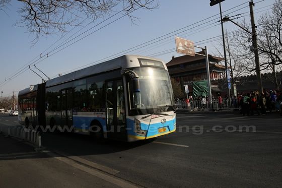 The trolley bus is passing by the north gate to Forbidden City