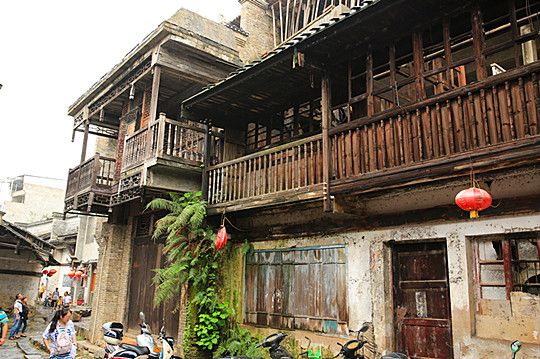 The two-story wooden house has ornate wood carvings