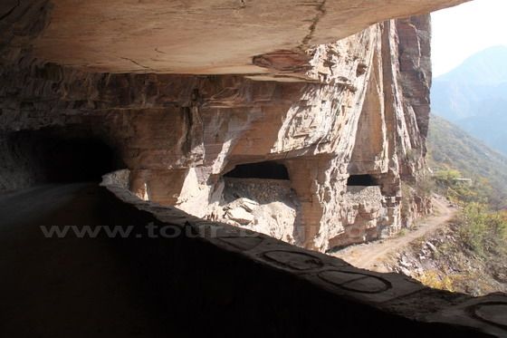 Through the huge roack window, I see the widing three-sided tunnel road.