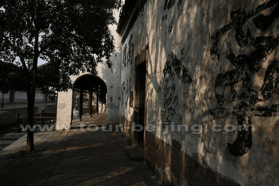 Walk along the white-washed wall building by the canal.