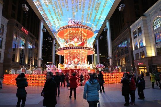 a large flower basket  decorated with horse toys and illuminated red lanterns.