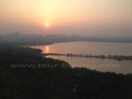 the bright sunlight leaves a thik red reflection on the water of the lake.